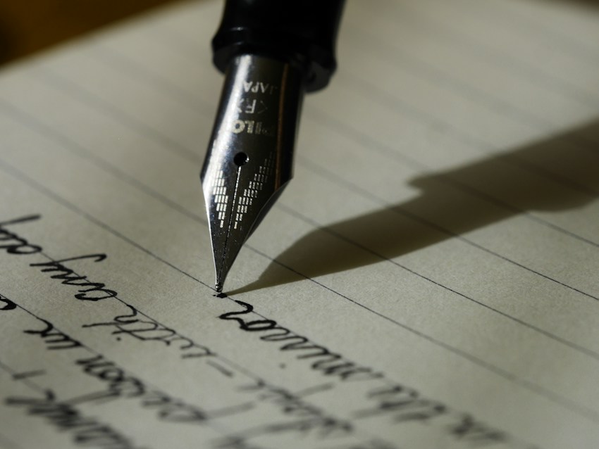 An open notebook beside a pen on a desk